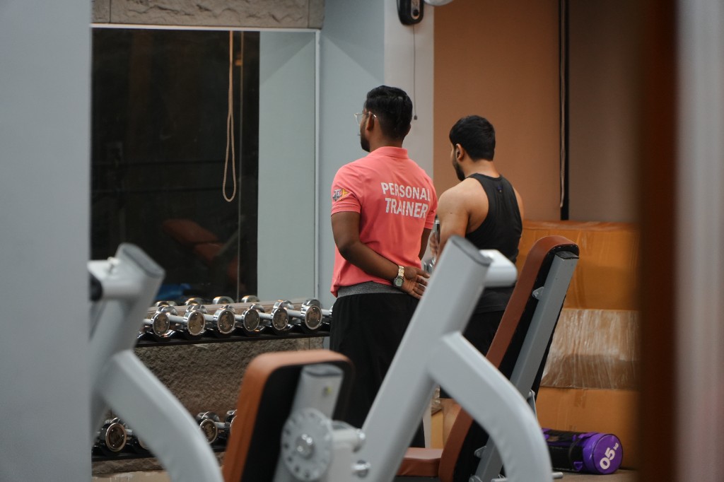 Personal trainer at the dumbbell rack